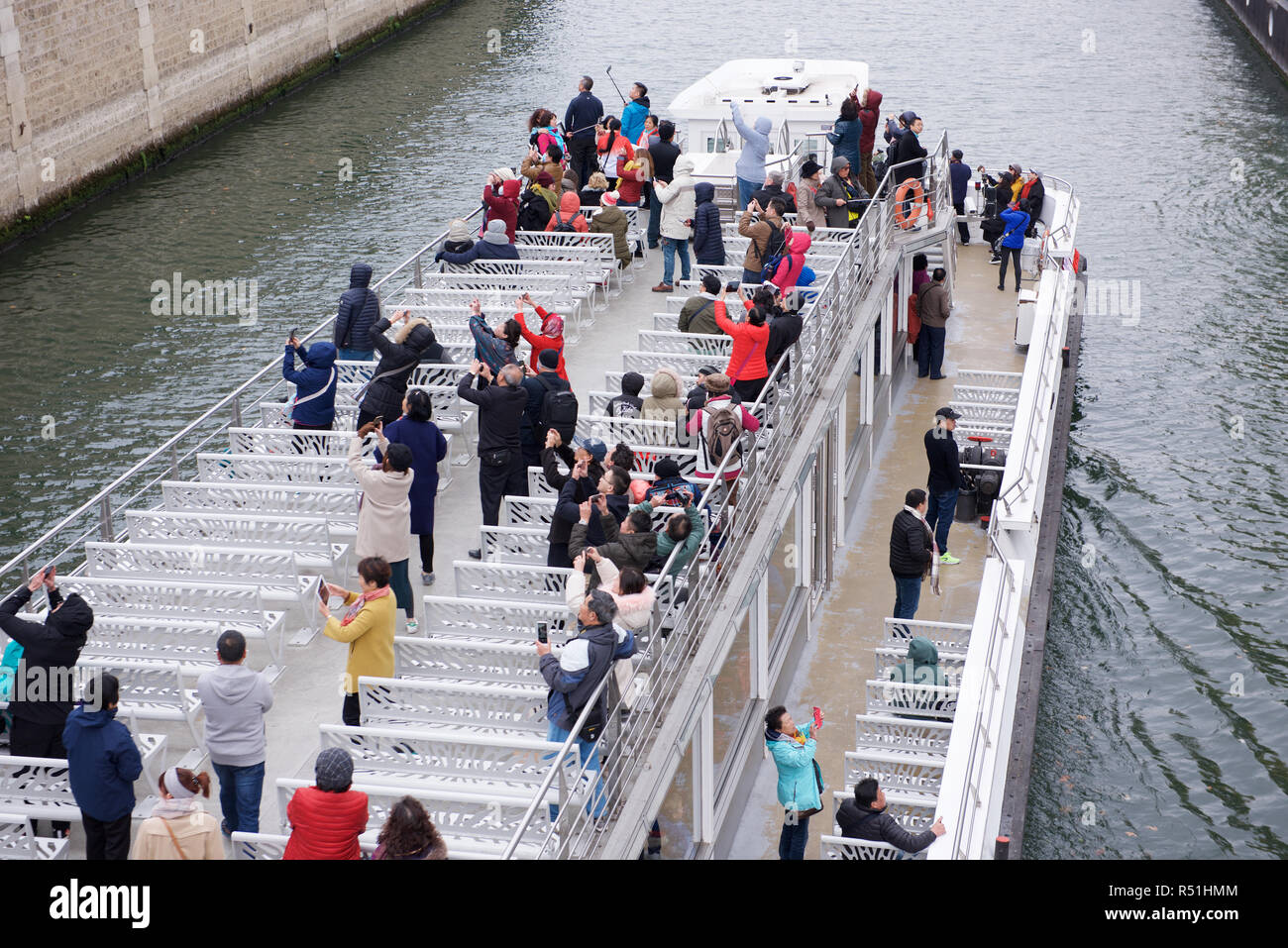 Tourists on a sightseeing boat with cameras in Paris, France Stock