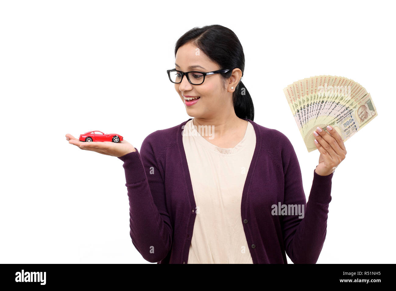 Young woman holding a toy car and Indian rupee notes Stock Photo