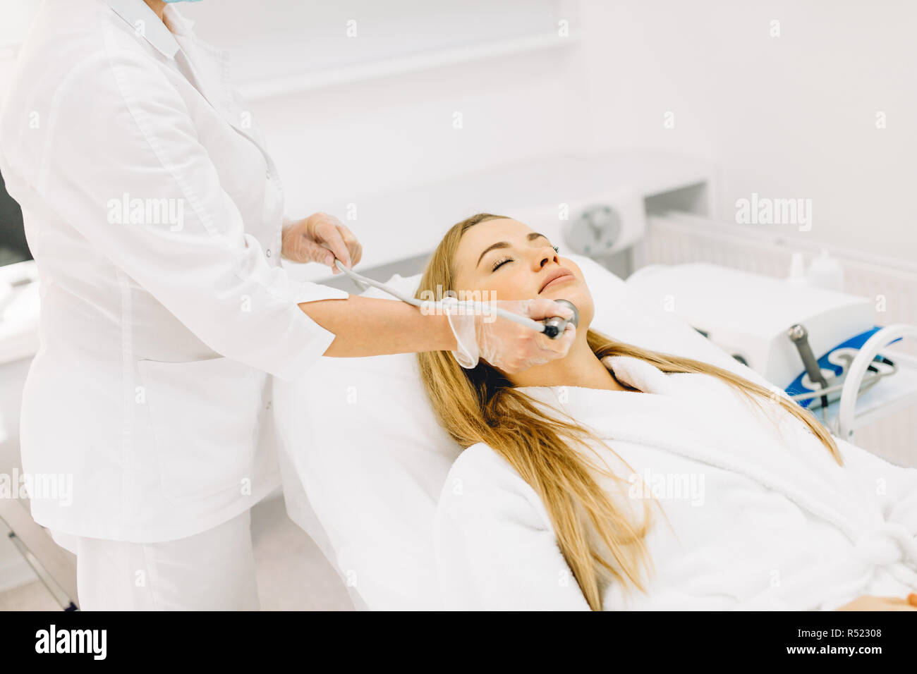Woman getting laser and ultrasound face treatment in medical spa center