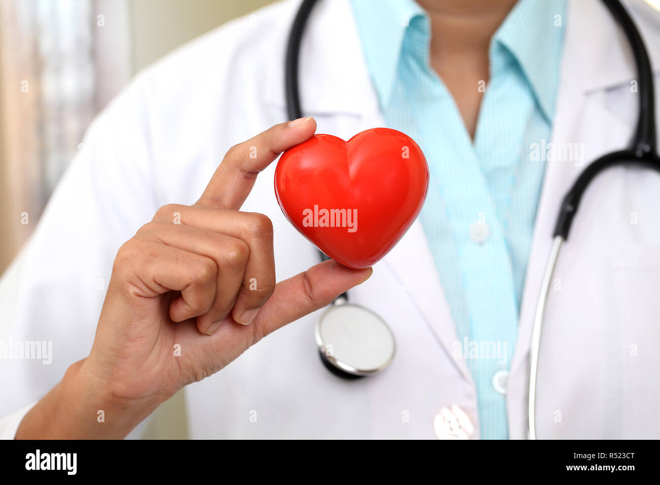 Female doctor holding a beautiful red heart shape Stock Photo