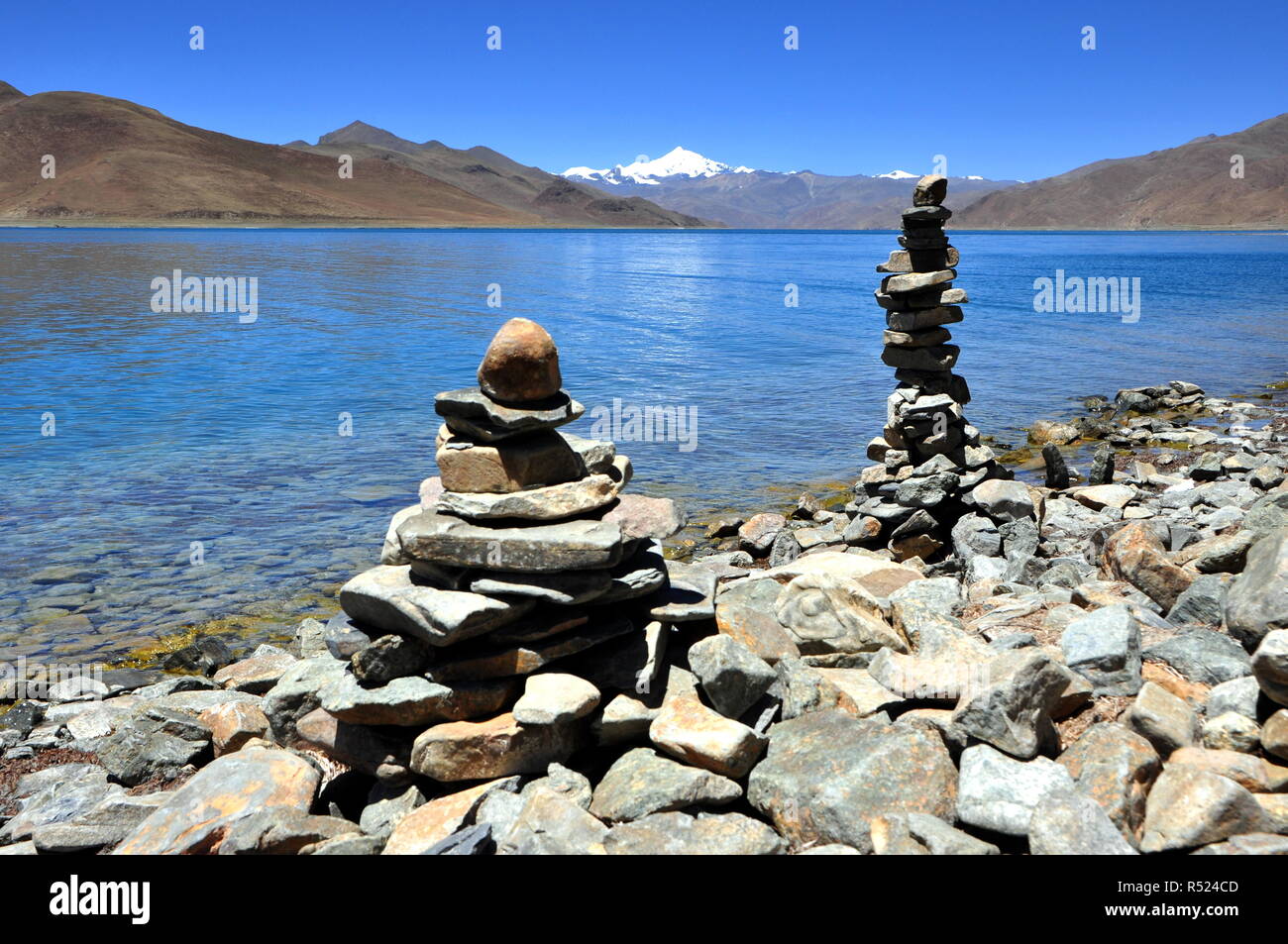 mani stone heap on the blue lake in tibet Stock Photo