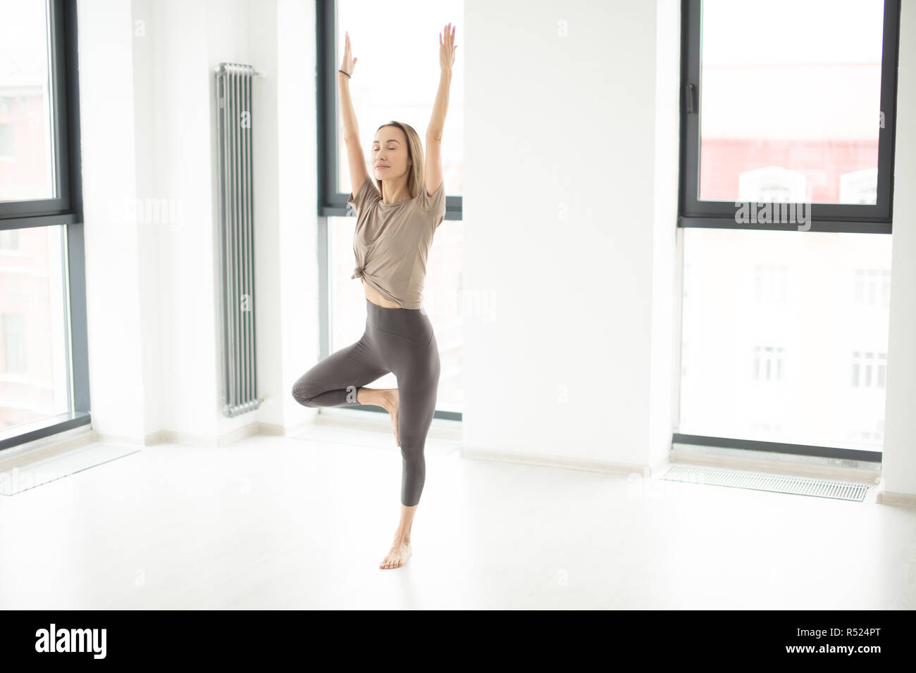 athlete standing in yoga position with raised arms Stock Photo Alamy