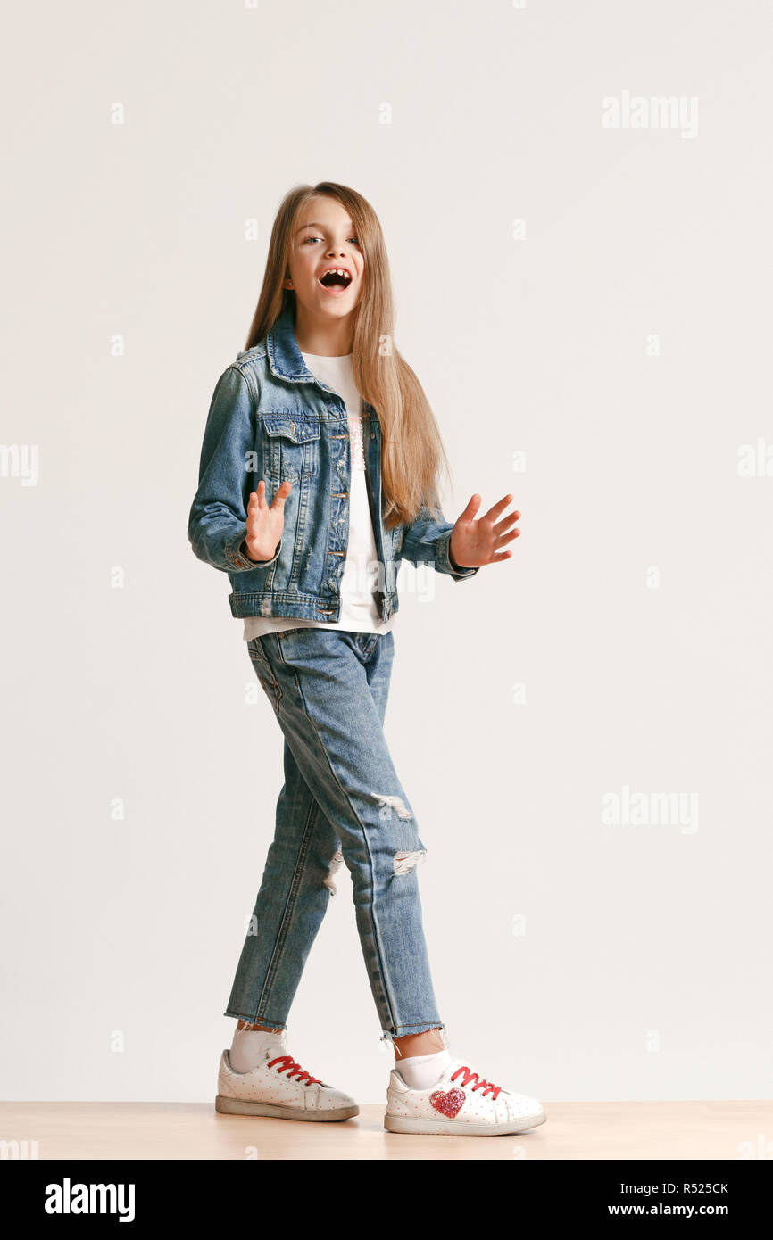 Full length portrait of cute little teen girl in stylish jeans