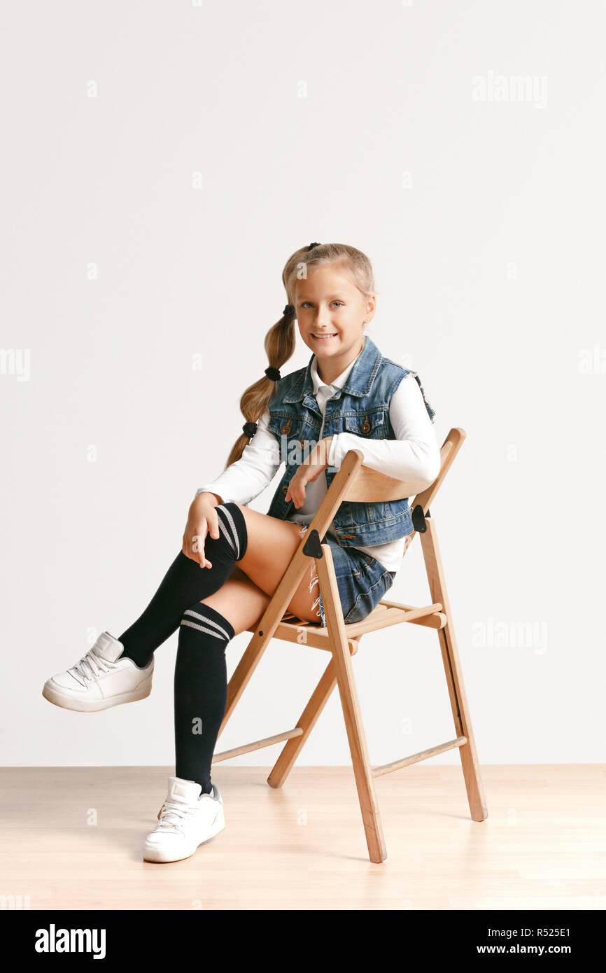 litle teen Full length portrait of cute little teen girl in stylish jeans clothes  looking at camera and smiling against white studio wall. Kids fashion  concept Stock Photo - Alamy