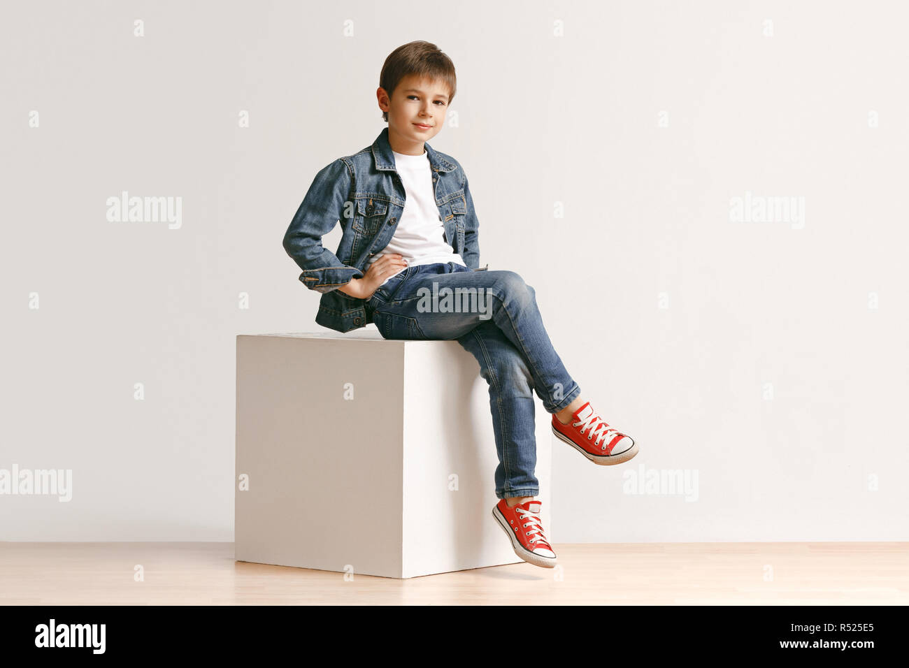 The portrait of cute little kid boy in stylish jeans clothes