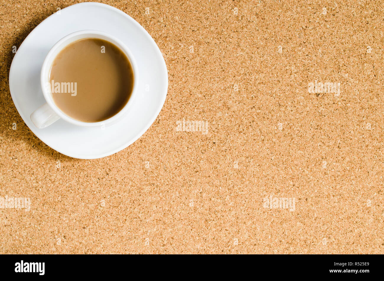 Cup of coffee on cork board. Stock Photo