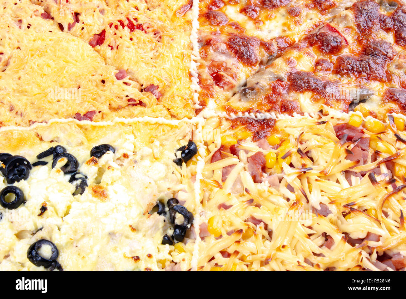quadruple topping family pizza closeup. sausage vs pork and corn vs mushrooms vs olives, in different kind of cheese. find your favorite Stock Photo