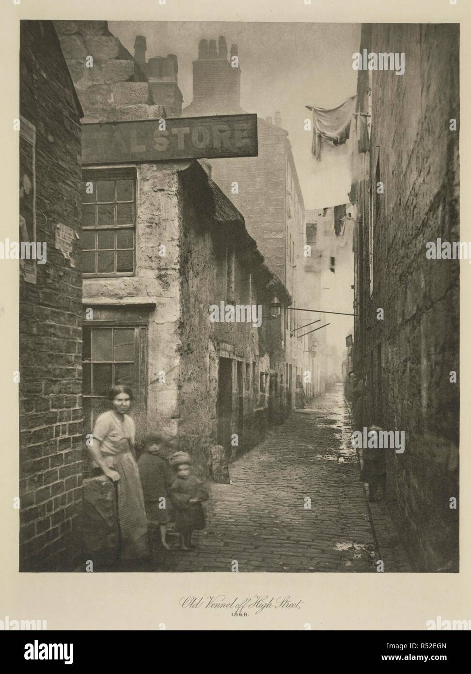 Old Vennel, off High Street, Glasgow, 1868. Ghostly moving figures populate Scottish photographer Thomas Annan's study of Old Vennel, off High Street, Glasgow. Annan was commissioned by The City Improvement Trust to document the inner-city slums which were scheduled for demolition and reconstruction by an act of Parliament in 1866. 'From High Street and about midway between the College and the Cross the Old Vennel branched eastwards, and turning to south beyond the Molendinar burn made straight for the Gallowgate, which it joined immediatly to the west of Little St. Mungo's Church.' Extract fr Stock Photo