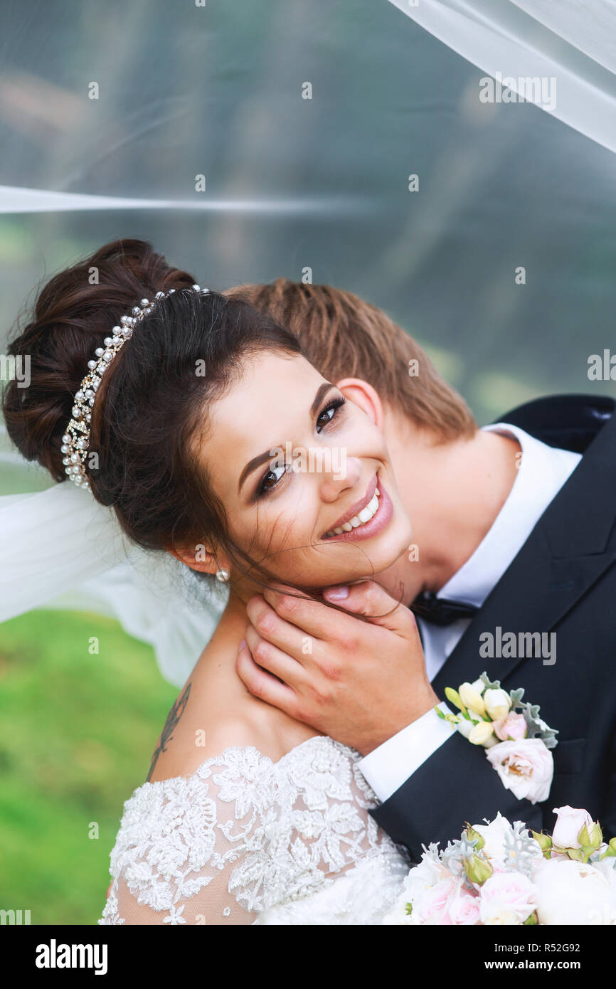 Bride and groom in a park kissing. Wedding couple in love Stock Photo ...