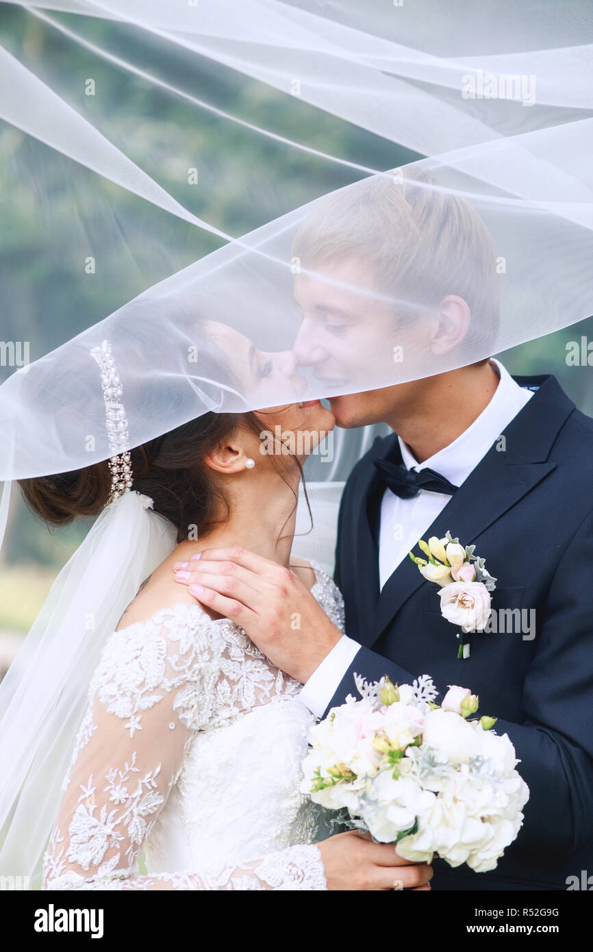 Bride and groom in a park kissing. Wedding couple in love Stock Photo ...