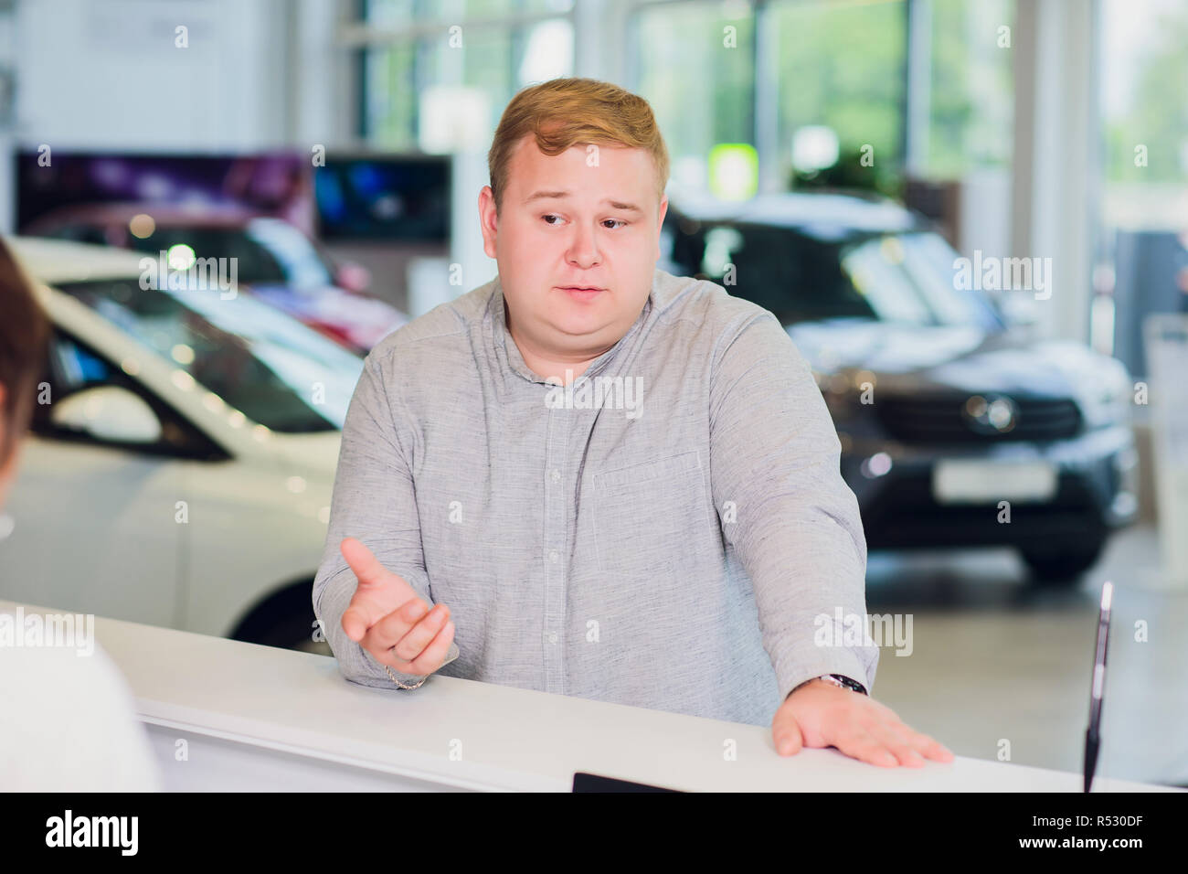 successful businessman in car dealership - sale of vehicles to customers Stock Photo