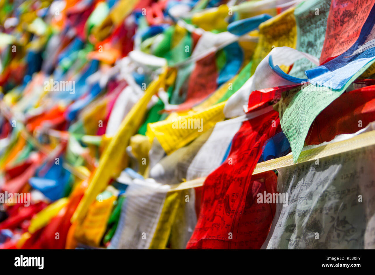Colorful Pataka(prayer flag) shot in Yunnan, China. It is believed that every time the flag flutters in the breeze, it chants the sutra. Stock Photo