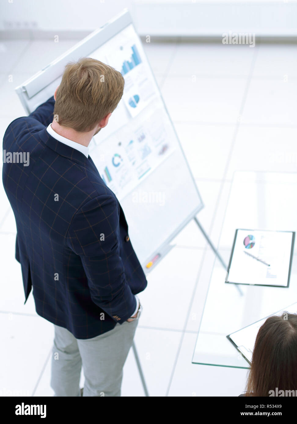Businessman giving flipchart presentation explaining idea to diverse partners Stock Photo