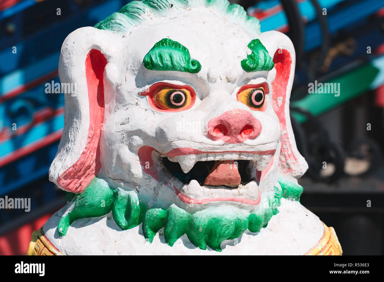 Stone statue of shishi lion covered with bright colors Stock Photo