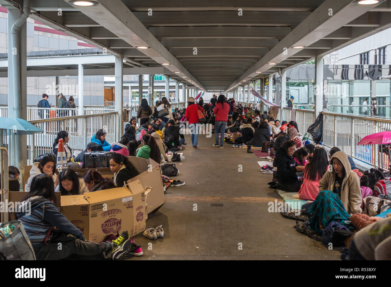 Female workers from Indonesia and the Philippines gathering on Sunday on a walkway in Admiralty district. Hong Kong, January 2018 Stock Photo
