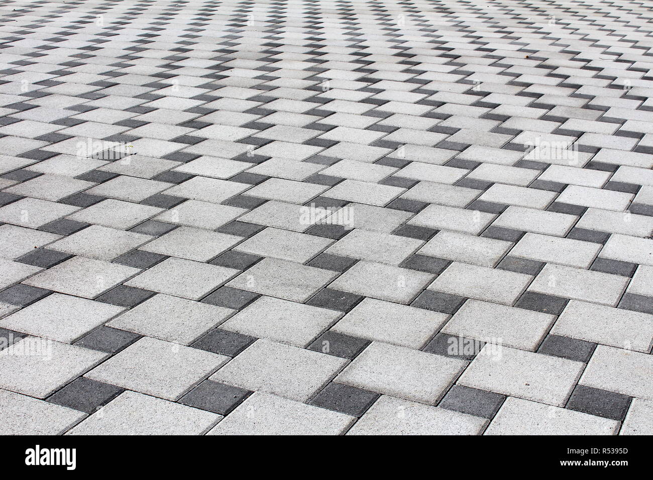 Light and dark stone tiles driveway made as optical depth illusion