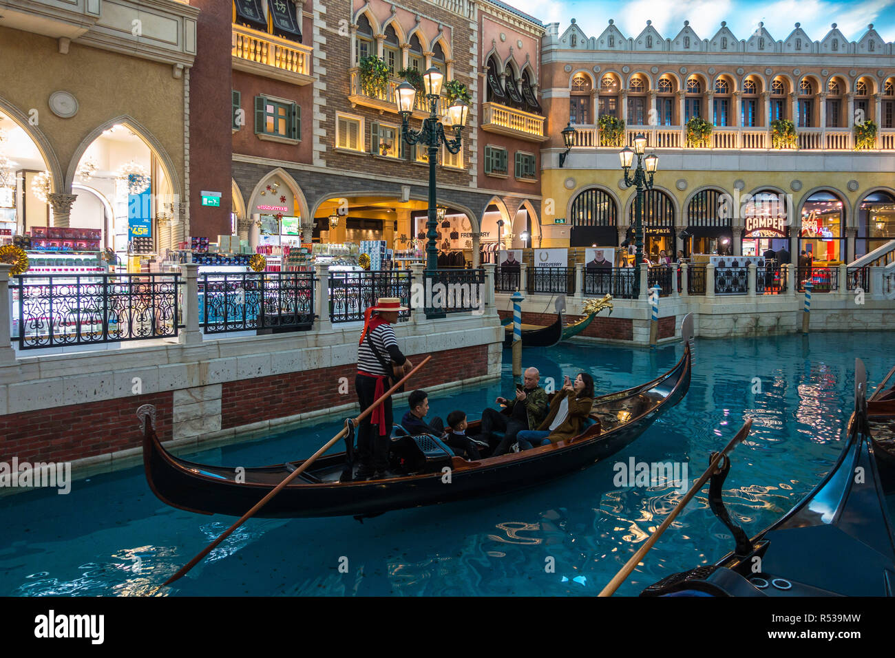 Tourists riding on the Gondola along artificial canal of the Venetian Macau, the largest casino in the world and luxury hotel. Macau, January 2018 Stock Photo