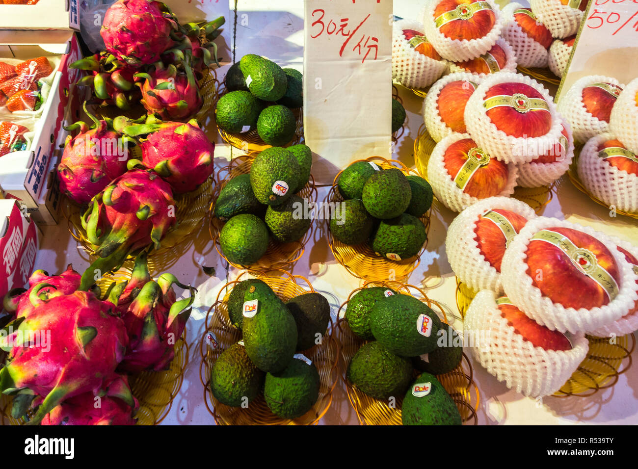 Dragon fruit, avocado and red apples on a market stall at Yau Ma Tei fruit market. Hong Kong