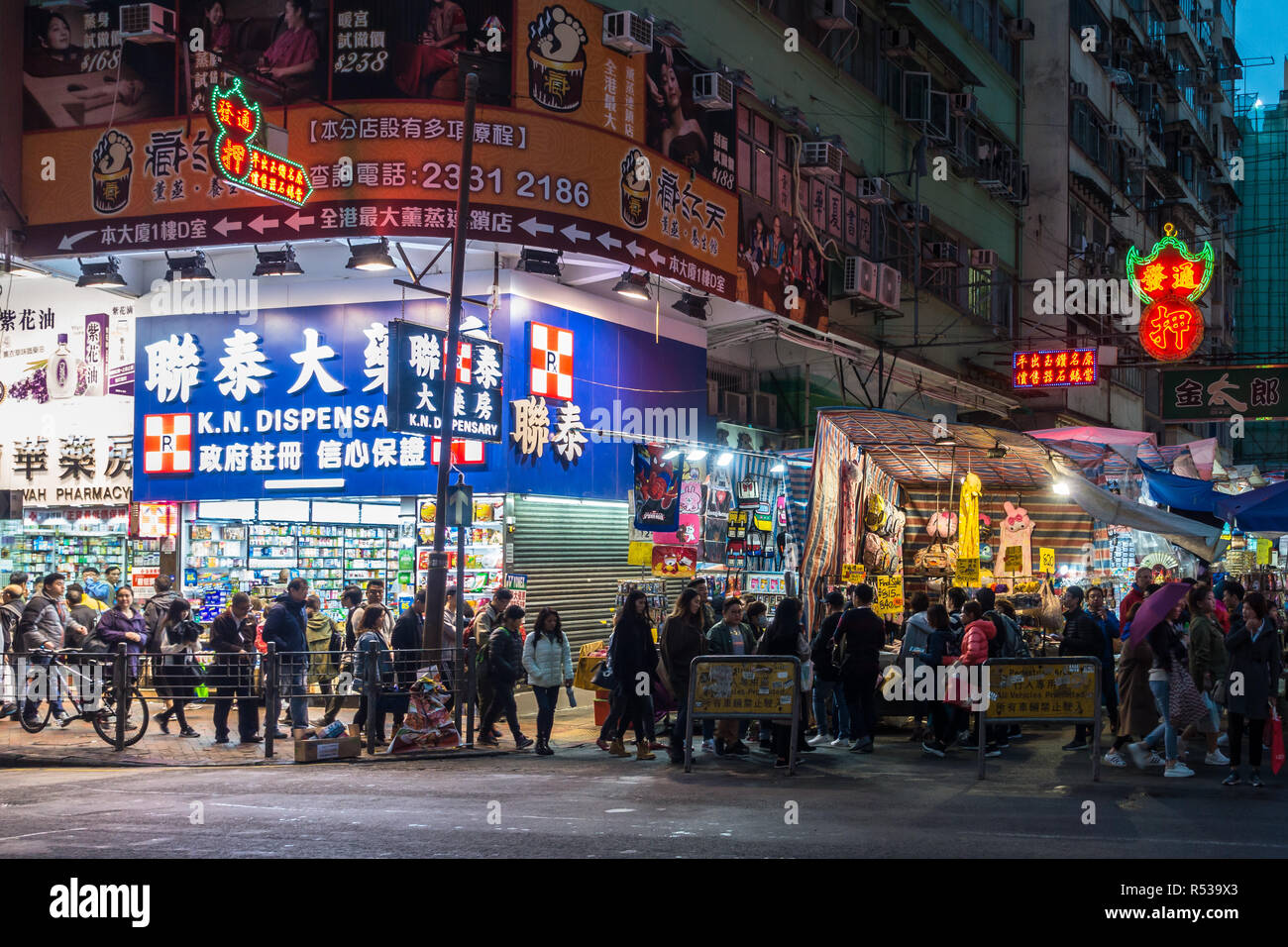 Nathan Road in Mong Kok area at late afternoon, full of people, street vendors and neon-lighted shops. Hong Kong, Kowloon, January 2018 Stock Photo