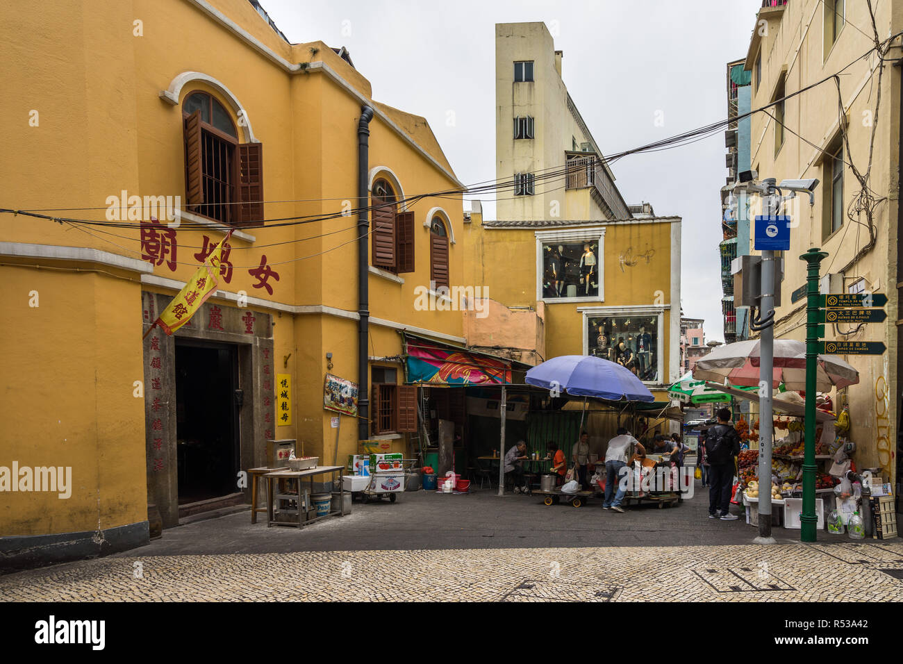 Street vendors in front of a small temple in Macau historic centre. Macau, January 2018 Stock Photo