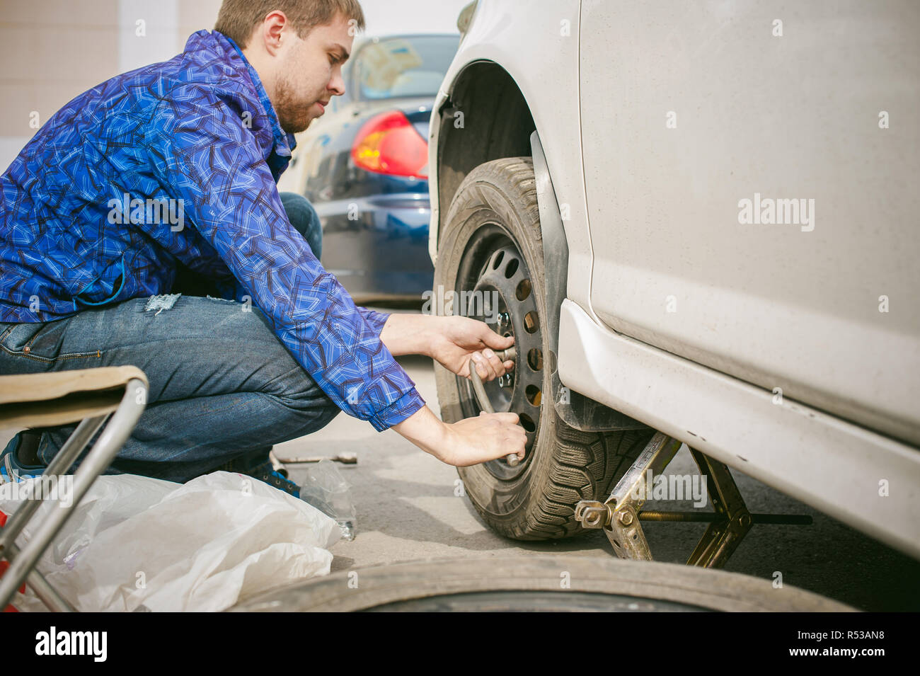 man changing a wheel on the road. on way there was breakage of wheel ...