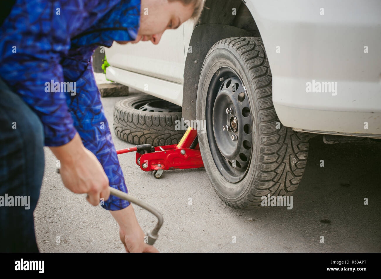 man changing a wheel on the road. on way there was breakage of wheel ...