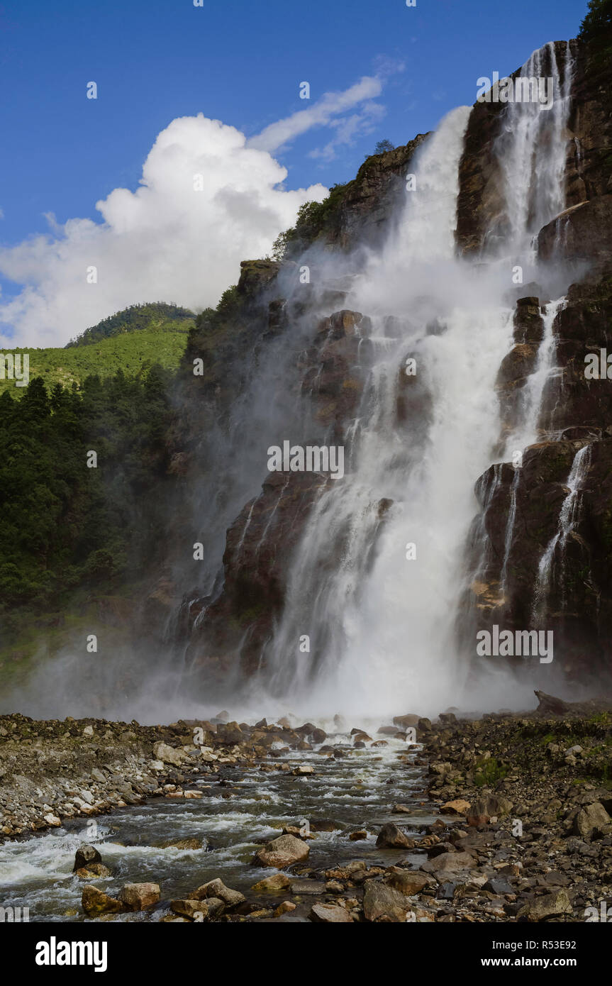 High waterfalls gush from high Himalaya mountains and into the Kameng river on a bright monsoon morning near Tawang, Arunachal Pradesh, India. Stock Photo