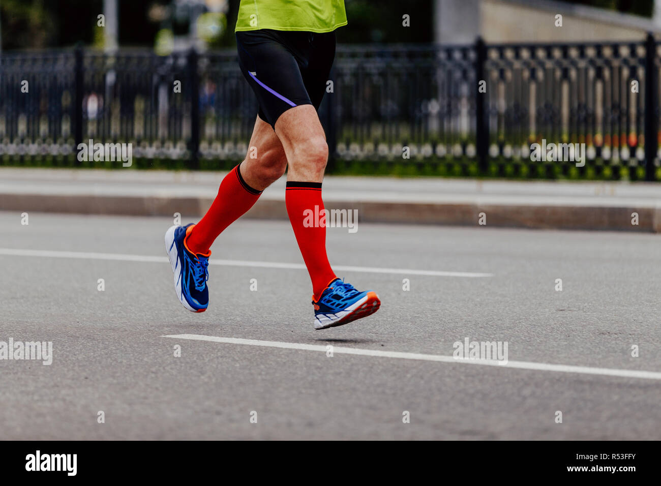 feet man runner in red compression socks running on road Stock Photo