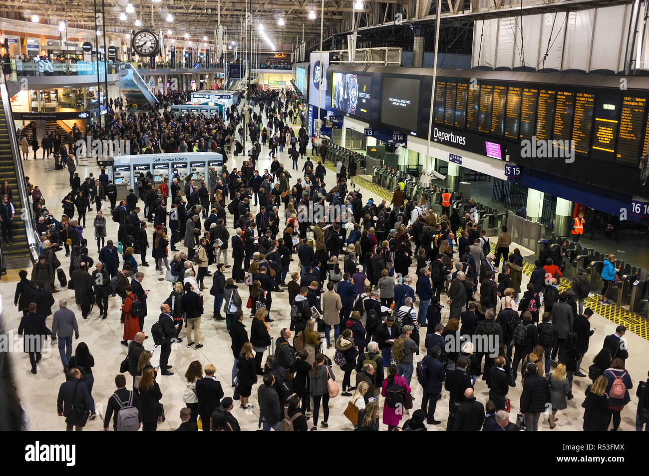 Rush hour commuters wait for the next train arrival information at Waterloo railway station in London. November 2018 Stock Photo