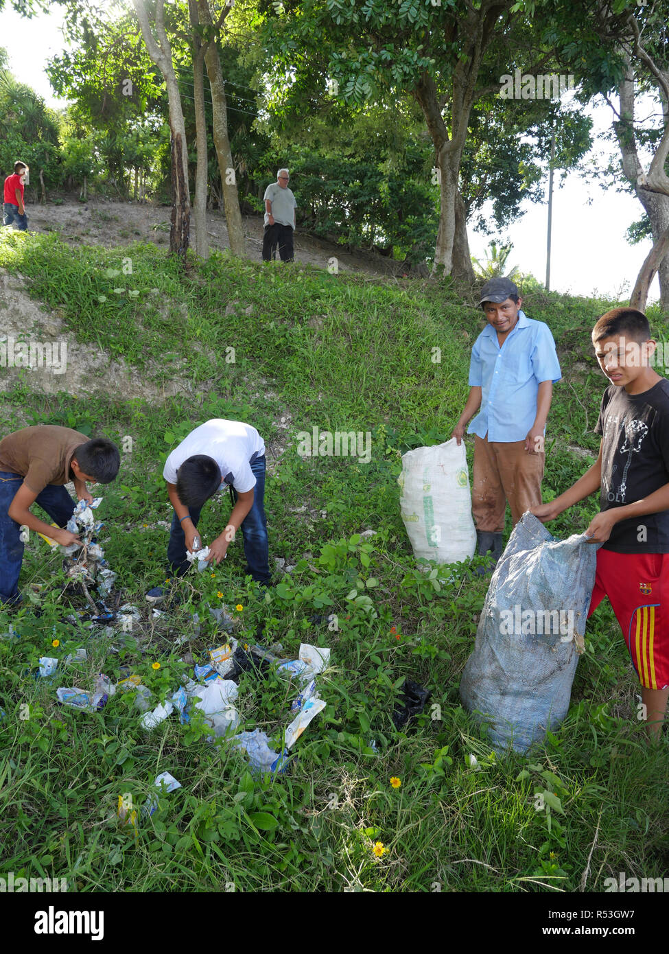 GUATEMALA  Rescue of the natural ecocsystem around Lake Nacanche, near El Remate, Peten. The Remate Parish Leadership and Formation team picking up litter, especially plastic, from the lake. Local children recruited to help with the clean-up operation. Stock Photo