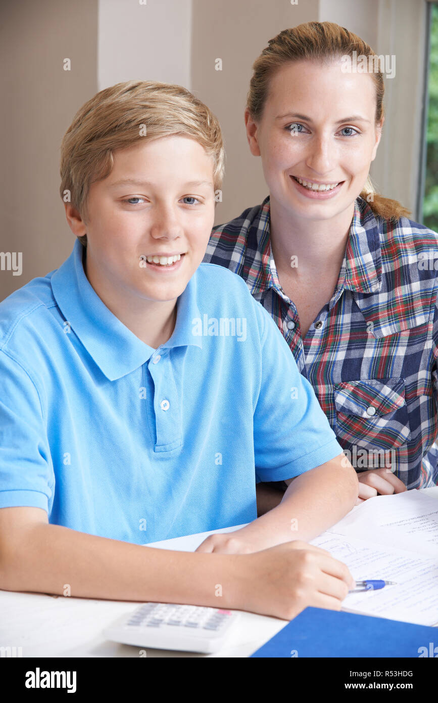 Female Home Tutor Helping Teenage Boy With Studies Stock Photo. 