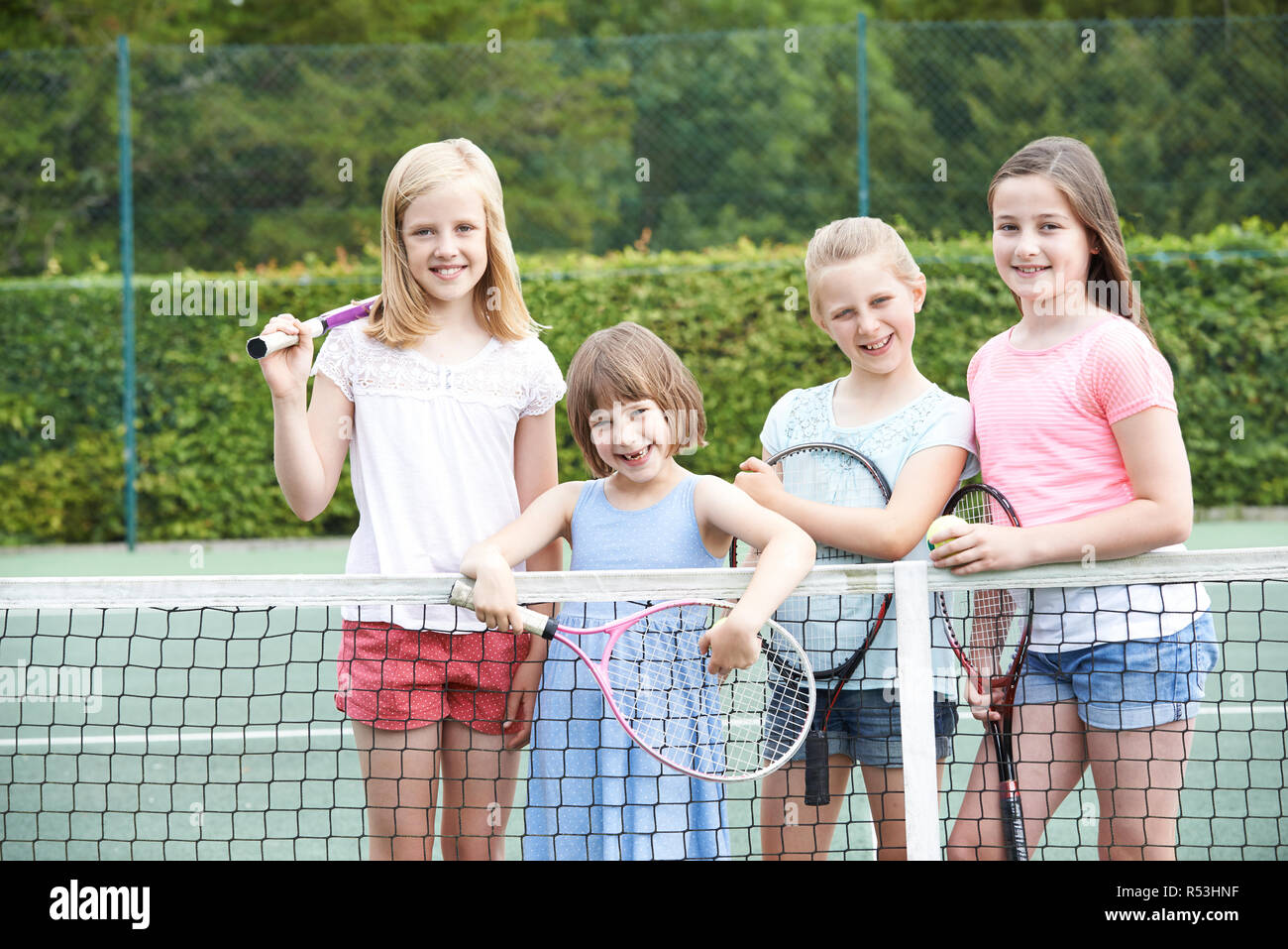 Portrait Of Group Of Girls Playing Tennis On Court Stock Photo