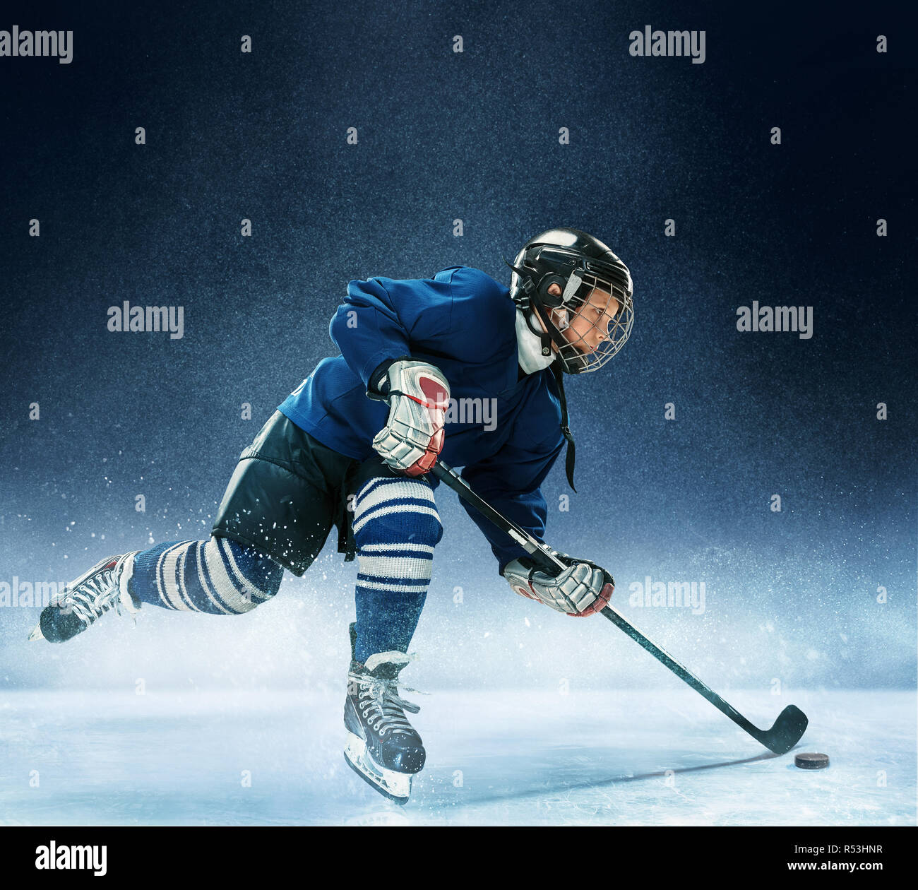 Little boy playing ice hockey at arena. A hockey player in uniform with