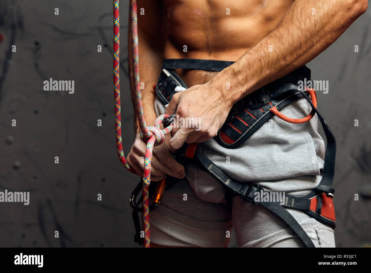 Climber s male hands with equipment during preparation for climb, close-up. Stock Photo
