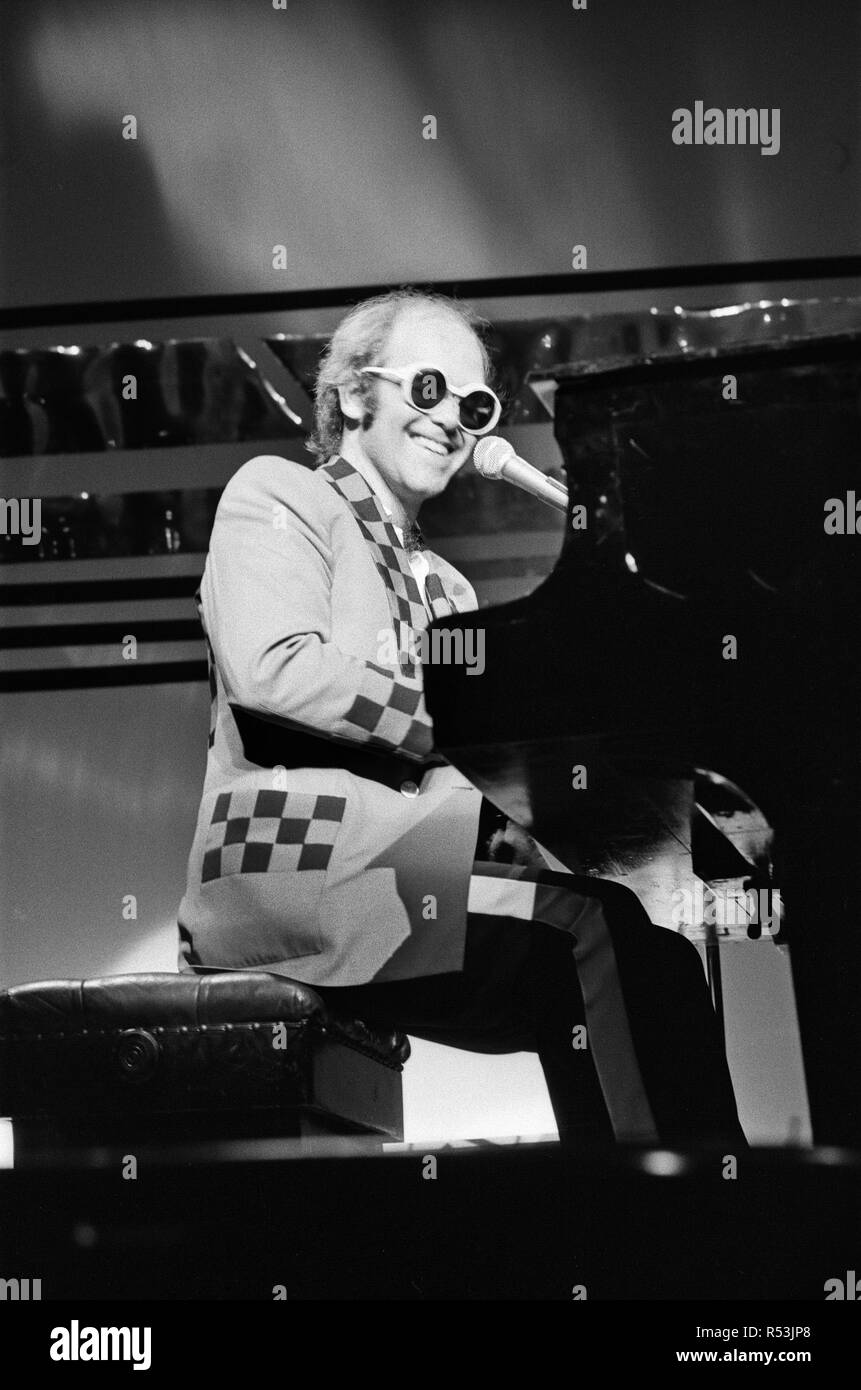 Elton John performing on stage, during the Elton John and Ray Cooper concert tours. Rainbow Theatre, London. 2nd May 1977. Stock Photo