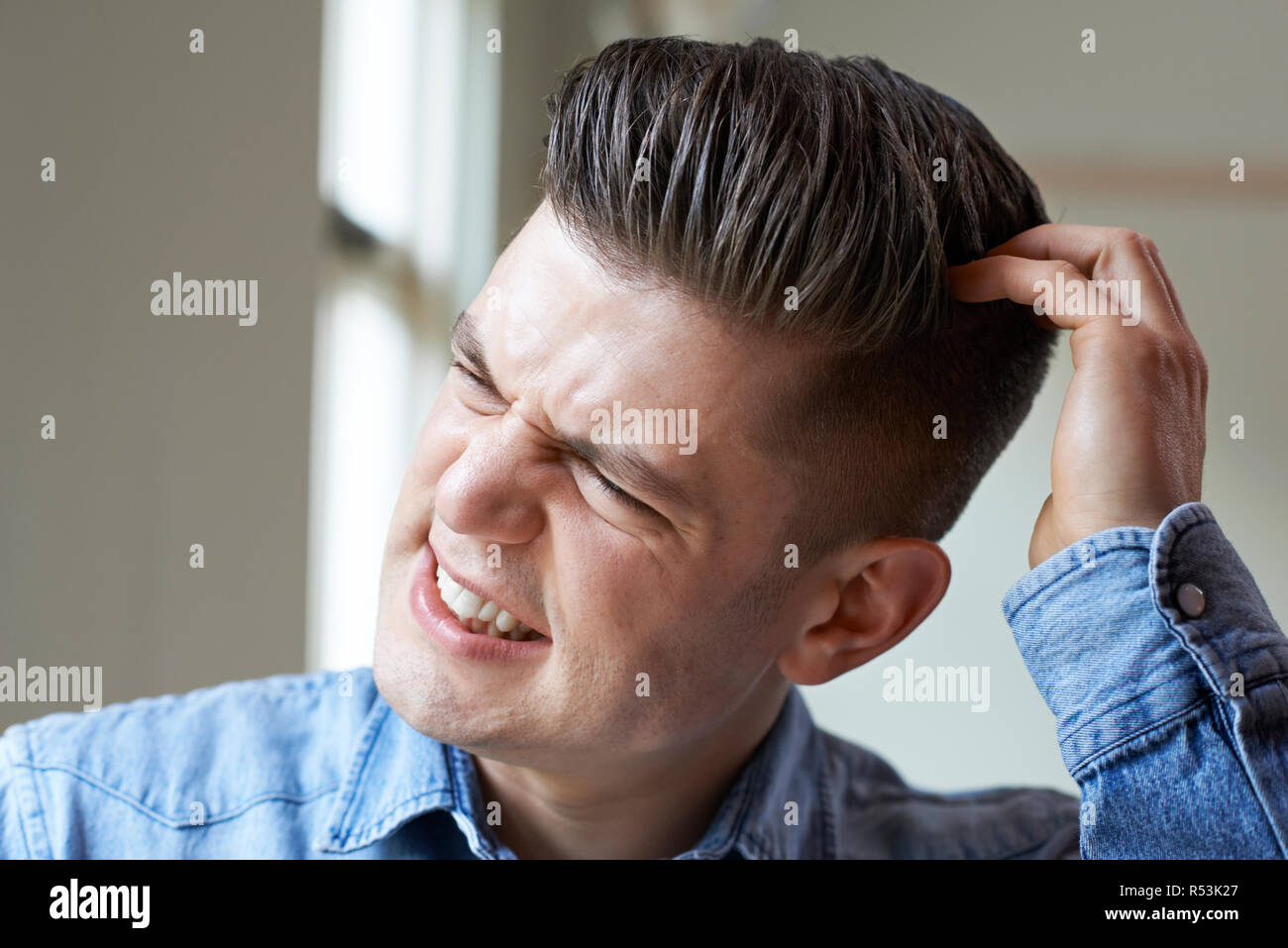 Shot Of Young Man Itching Scalp Stock Photo