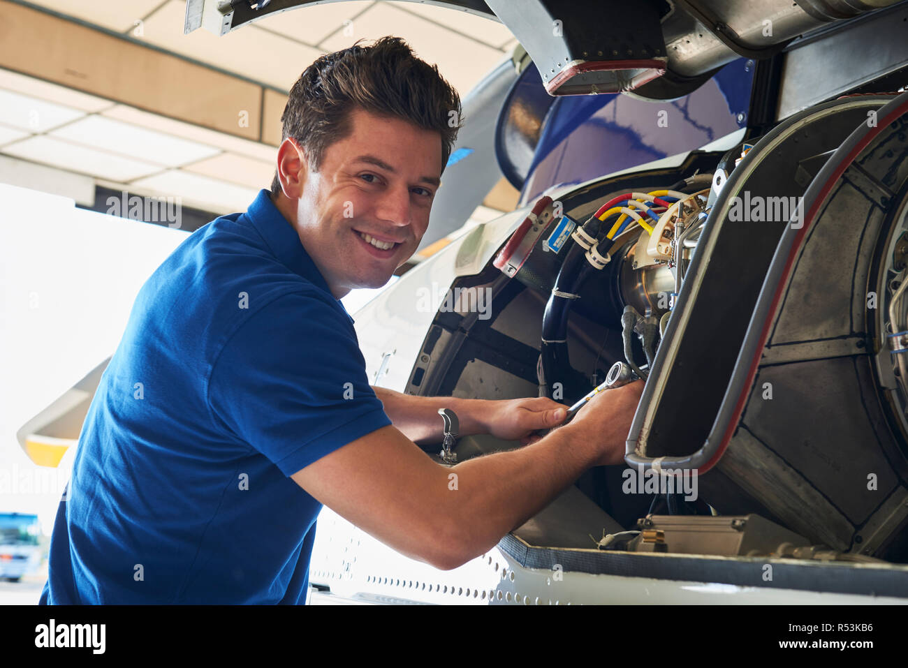 Portrait Of Male Aero Engineer Working On Helicopter In Hangar Stock Photo