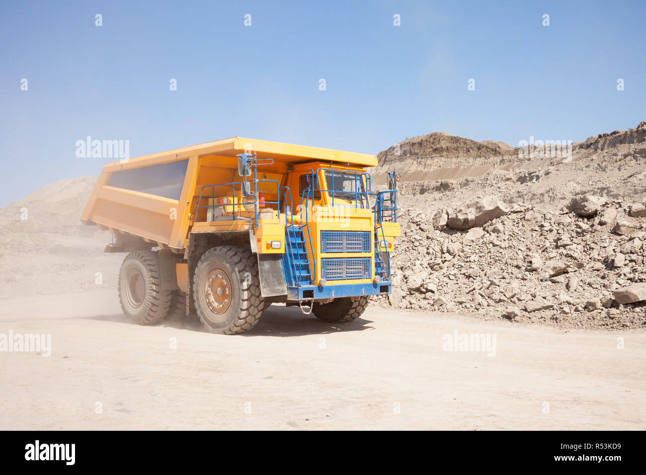 Yellow dump truck moving in a coal mine Stock Photo