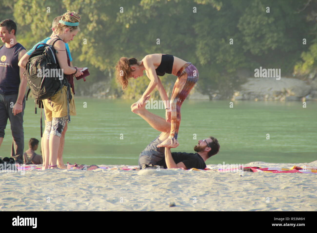 International students performing acro yoga at Ganga Beach, Rishikesh, India Stock Photo