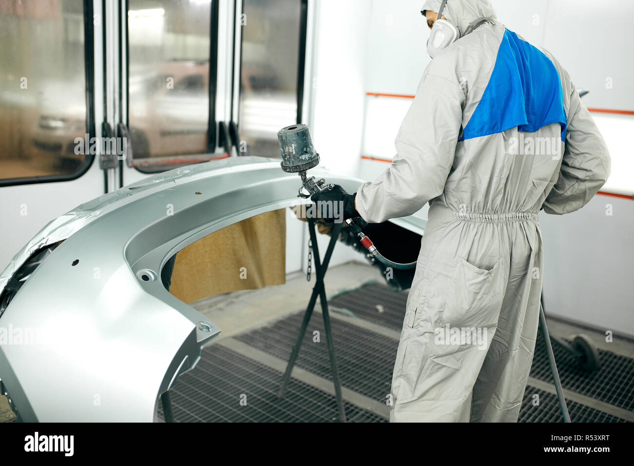 Worker Painting Car Parts In Special Garage Wearing Costume And