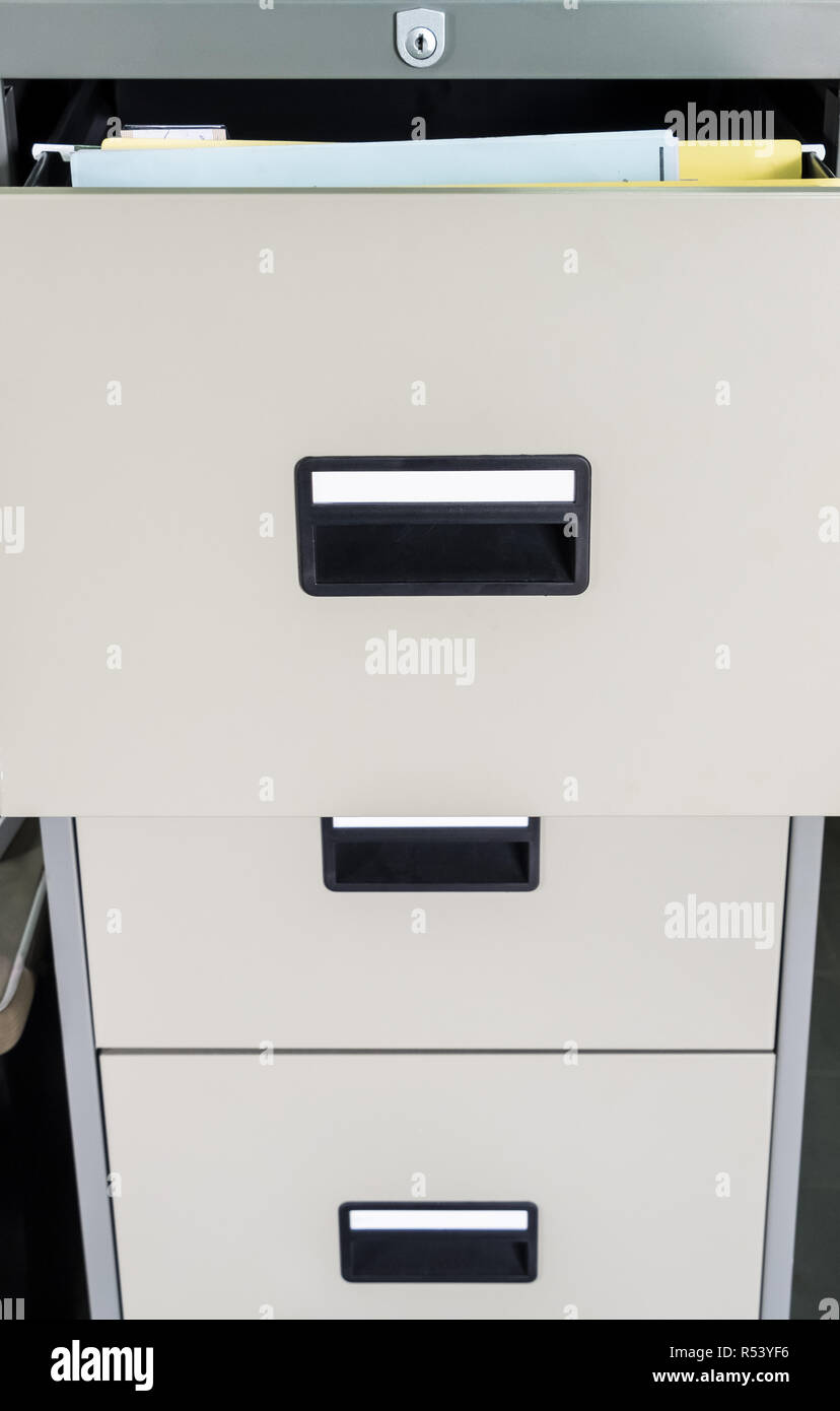 Metal file cabinet with open drawer for searching the private document. Stock Photo