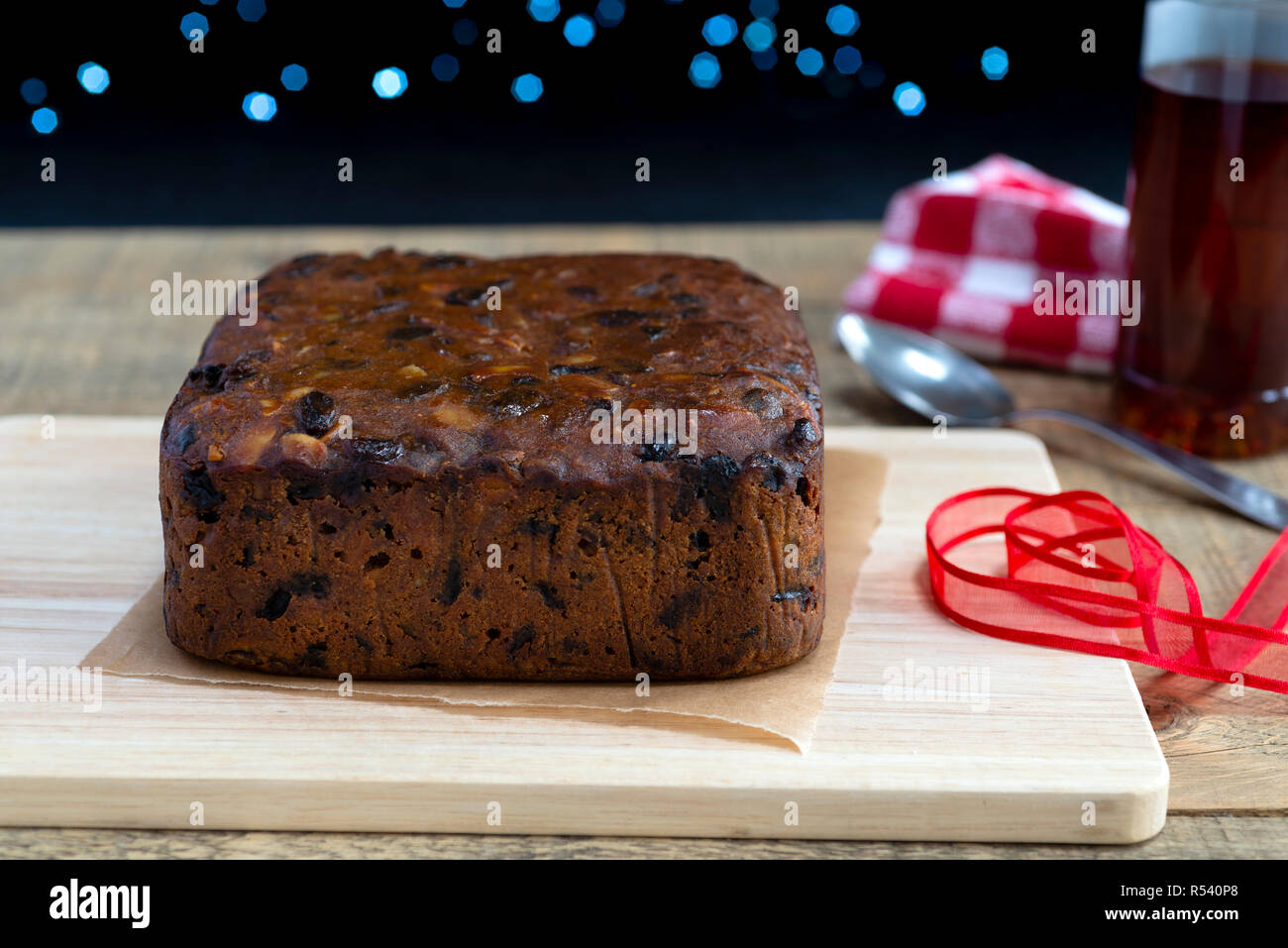 Preparing to 'feed' a rich fruit Christmas cake by pouring brandy over it Stock Photo Alamy