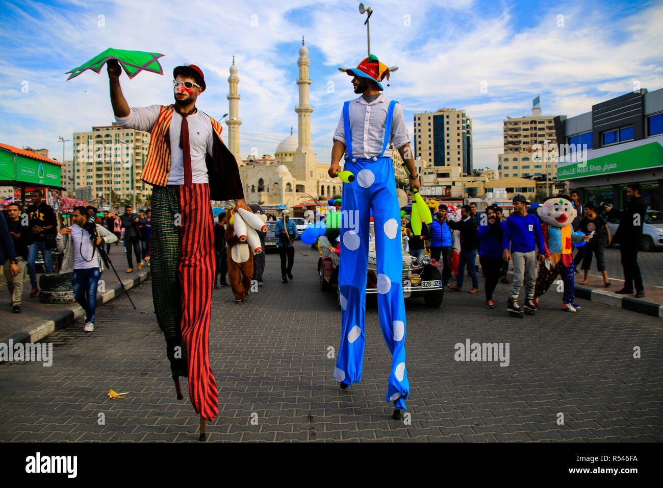 A street carnival with a parade of customs, clowns, circus jugglers ...