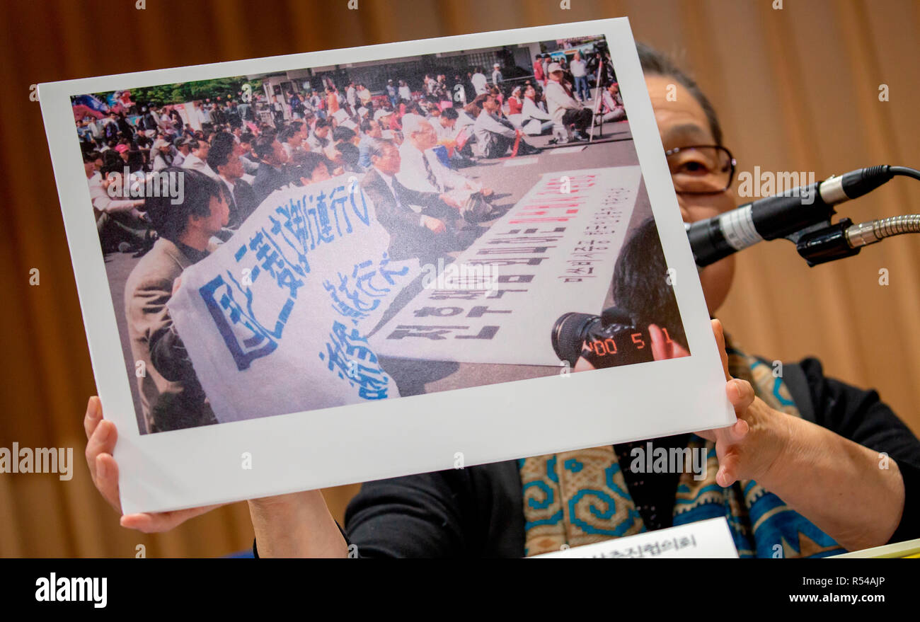 Lee Hee-Ja, Nov 29, 2018 : Lee Hee-Ja, co-president of the Korean Council for Compensation for the Victims of World War II, shows an old picture of South Korean victims of Japan's forced labor during World War II, who were attending a protest, as she speaks at a press conference at the Seoul Bar Association near the Supreme Court in Seoul, South Korea after the Supreme Court's ruling on damages suits. According to local media, South Korea's Supreme Court ordered Mitsubishi Heavy Industries to compensate 10 Koreans who worked at its shipyard and other production facilities in Hiroshima and Nago Stock Photo