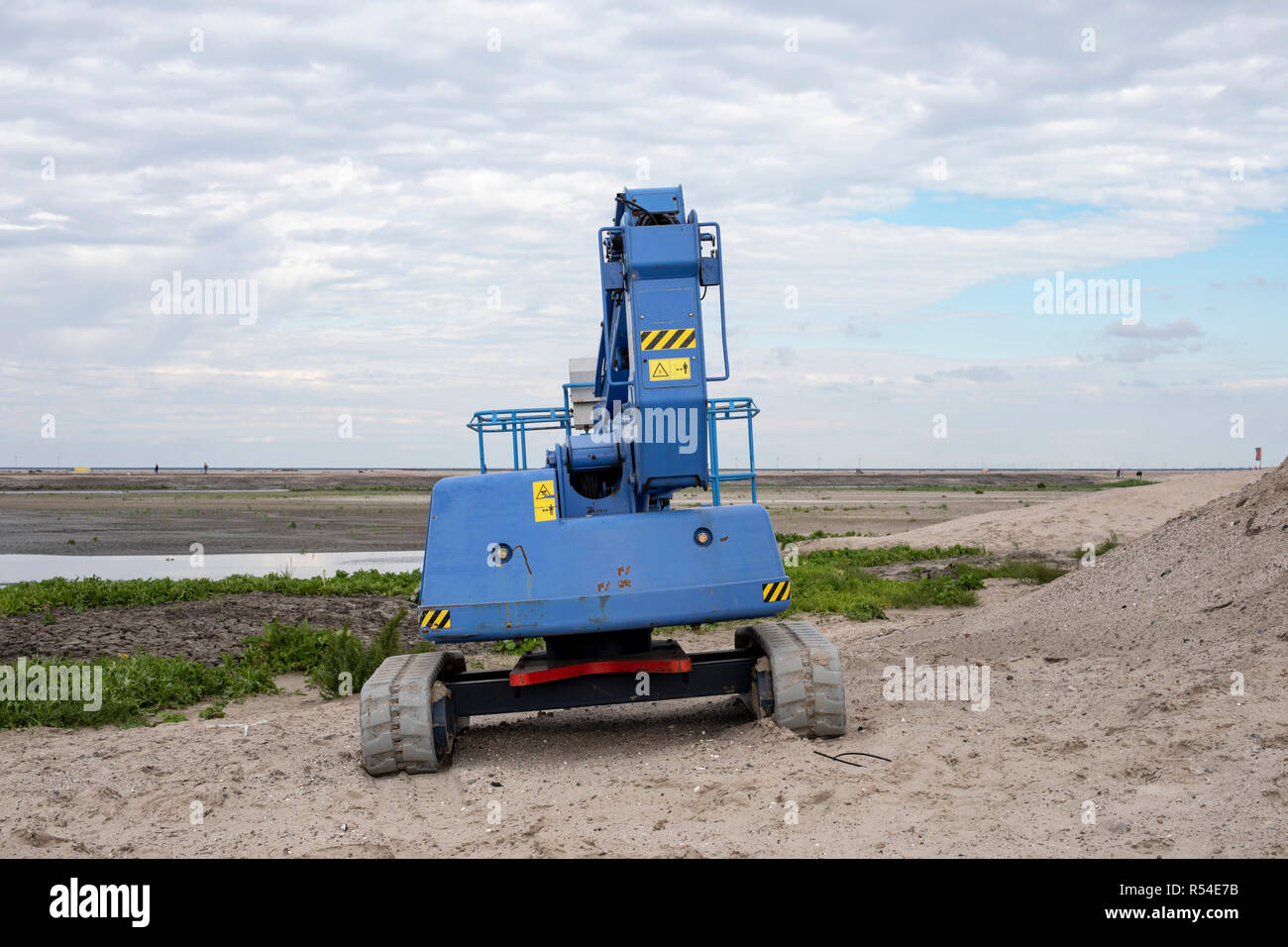 A blue tractor used for creating the marker wadden, an artificial archipelago in development located in the Markermeer. Stock Photo