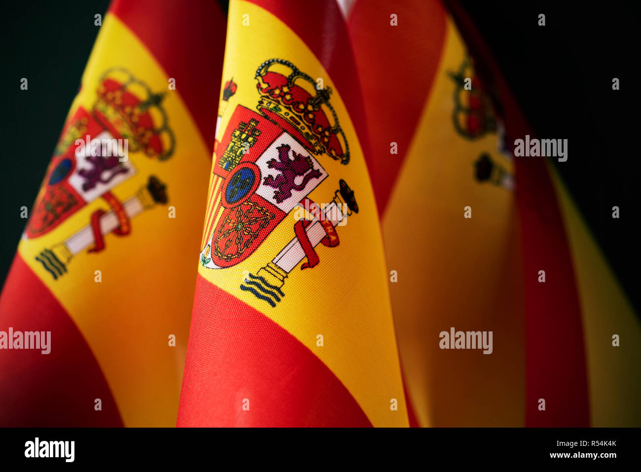 closeup of some flags of spain against a dark background Stock Photo