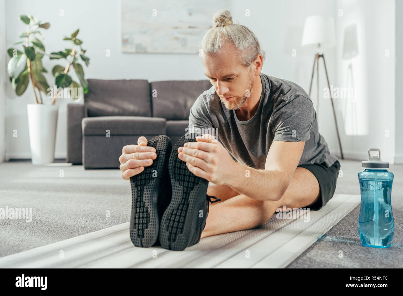Man sportsman training at home, stretching exercises for arm, leg and back  muscles, strong body and correct posture, the concept of health and beauty  Stock Photo - Alamy