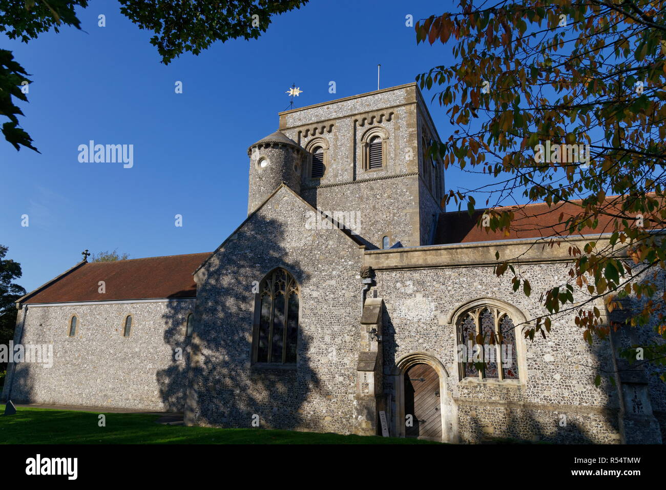 St Mary's church through tree branchs with leaves Kingsclere Hampshire Stock Photo