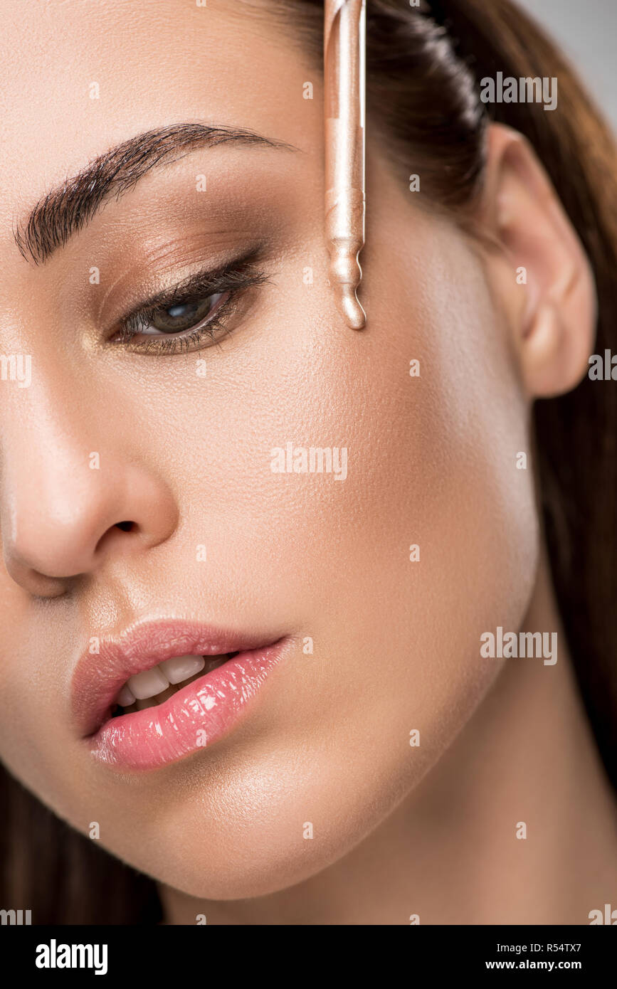 attractive girl applying highlighter or bronzer with pipette Stock