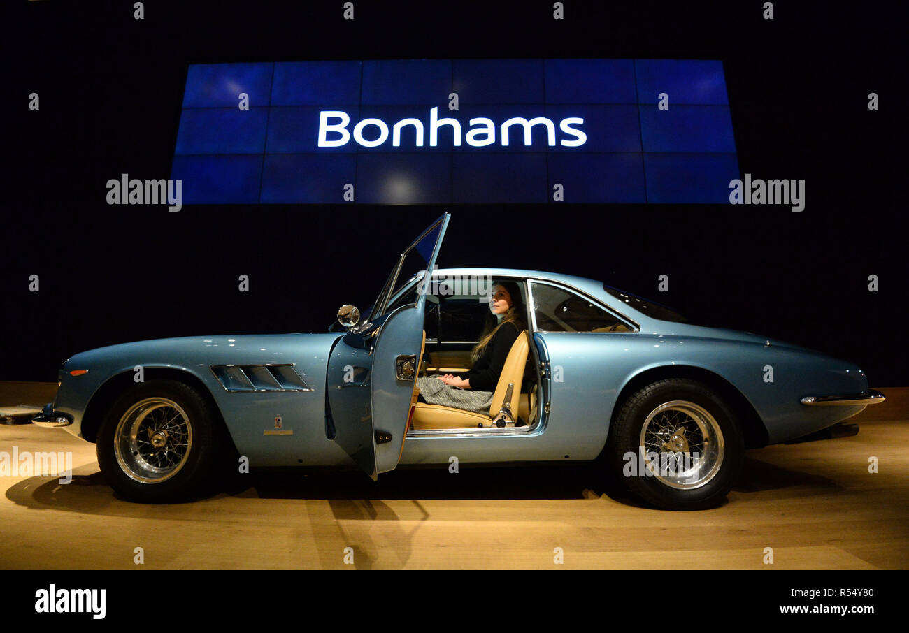Auction house assistant Becky sits in a 1966 Ferrari 500 Superfast Series II Coupe, during a photo call for £20m supercars before they are offered at auction, at Bonhams in New Bond Street, London. Stock Photo